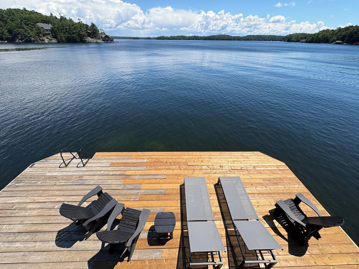 Sun loungers and Muskoka chairs on the boathouse dock looking up the lake