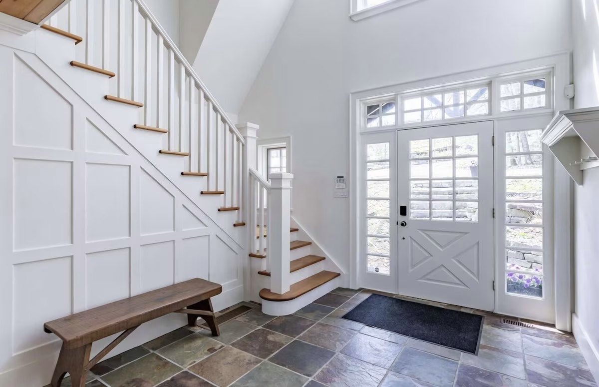 Front hall with a white staircase, slate floor, and a divided-light entry door