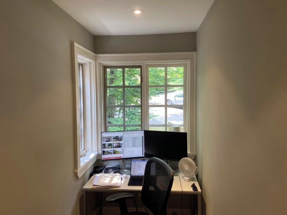 Second-floor office with a desk in a bay window looking onto the drive