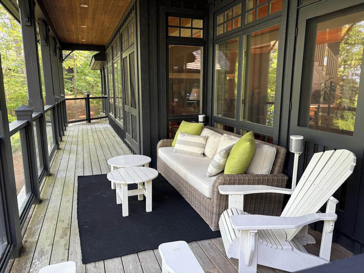 Wicker sofa and Adirondack chairs on the covered porch